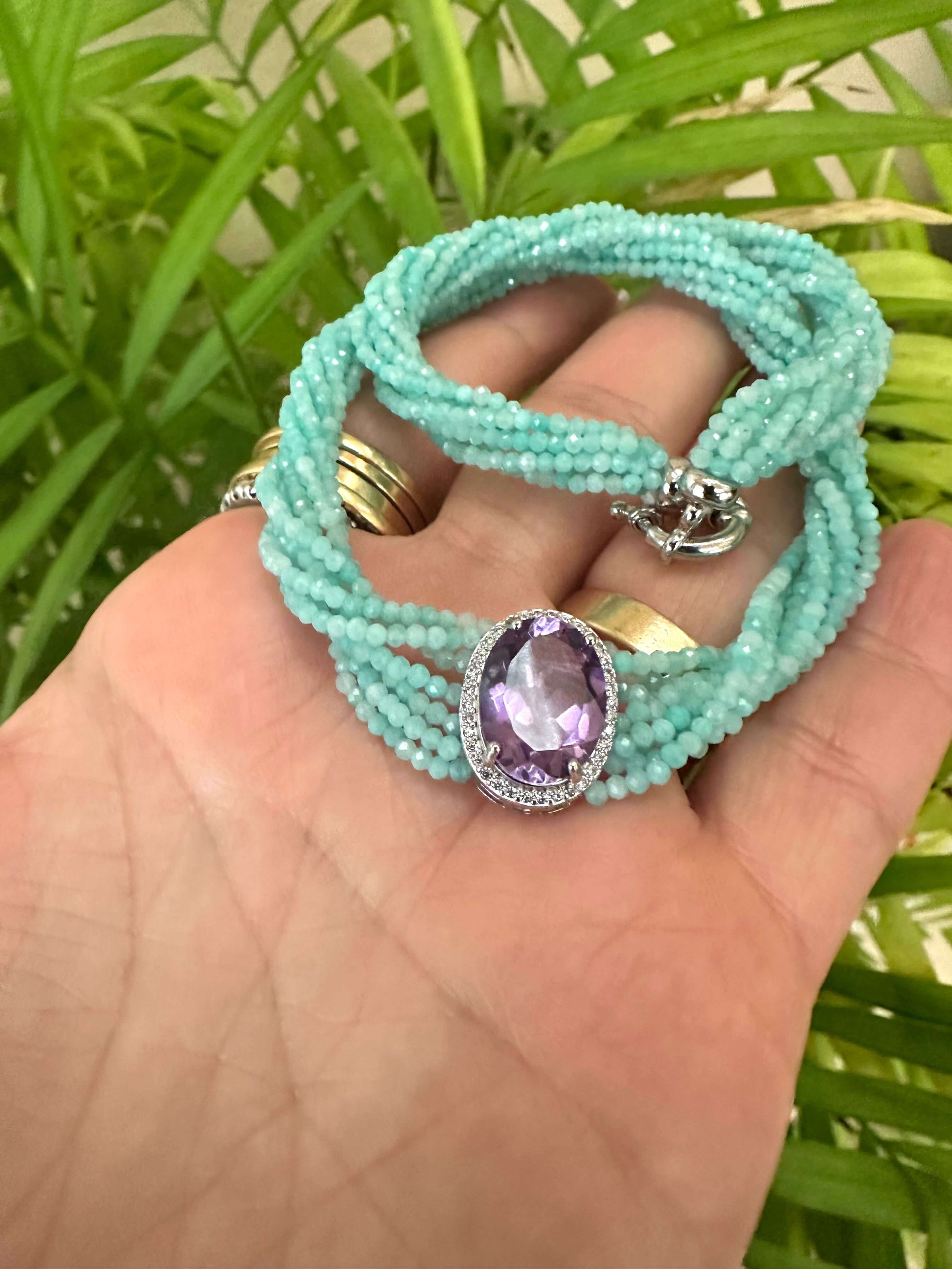 Amethyst Amazonite Choker Necklace – 8-Strand Twisted Gemstone Collar displayed on a hand with green foliage.
