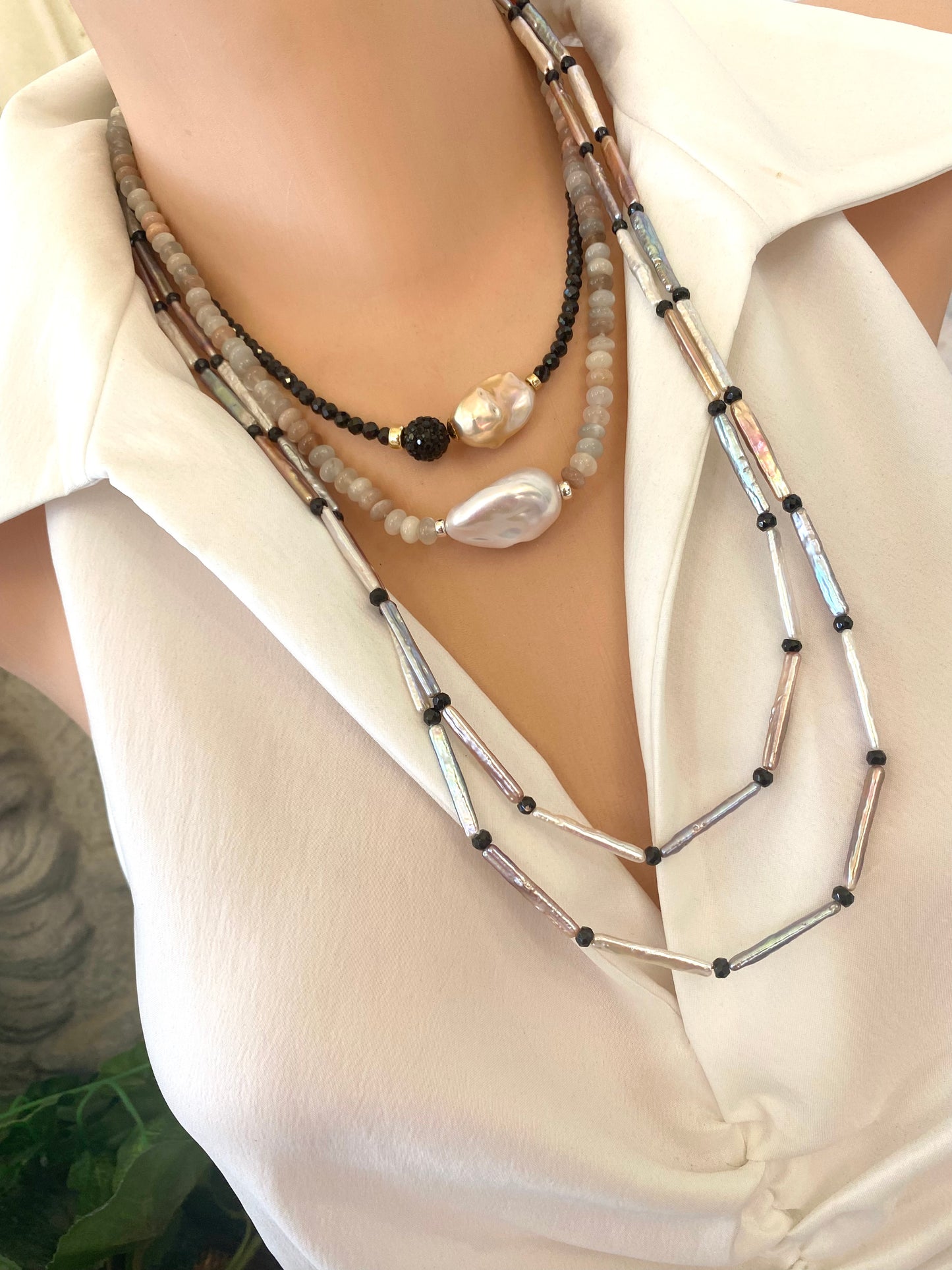 Black spinel pearl necklace worn on mannequin, side view layered with longer strands