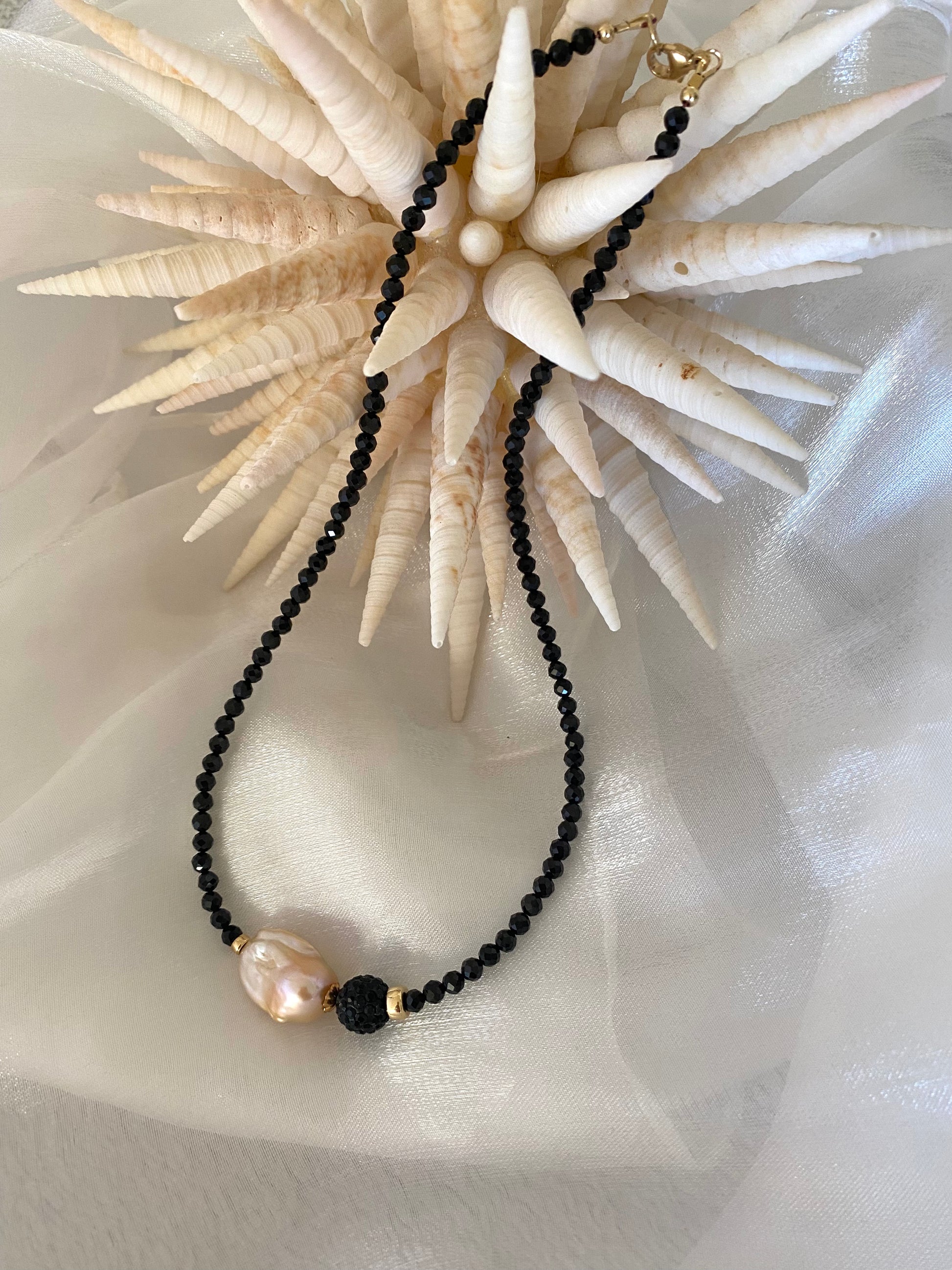 Black spinel pearl necklace displayed on white cloth