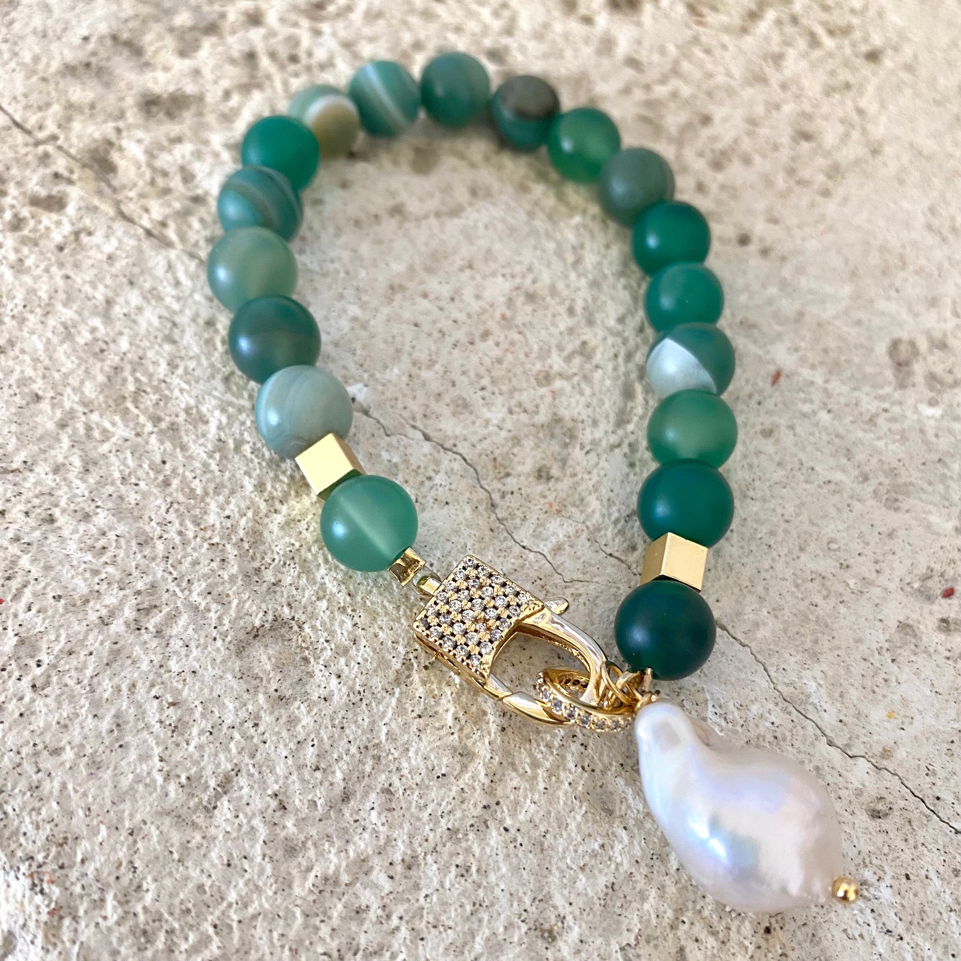 Sardonyx baroque pearl bracelet with green beads and gold clasp displayed flat