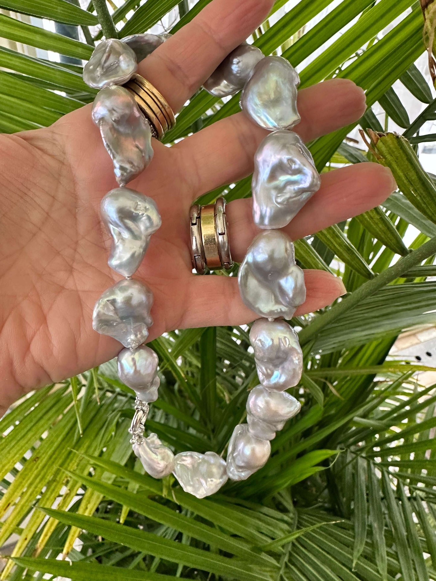 Handmade baroque pearl necklace with silver details, showcasing large silver-grey pearls and natural iridescence.
