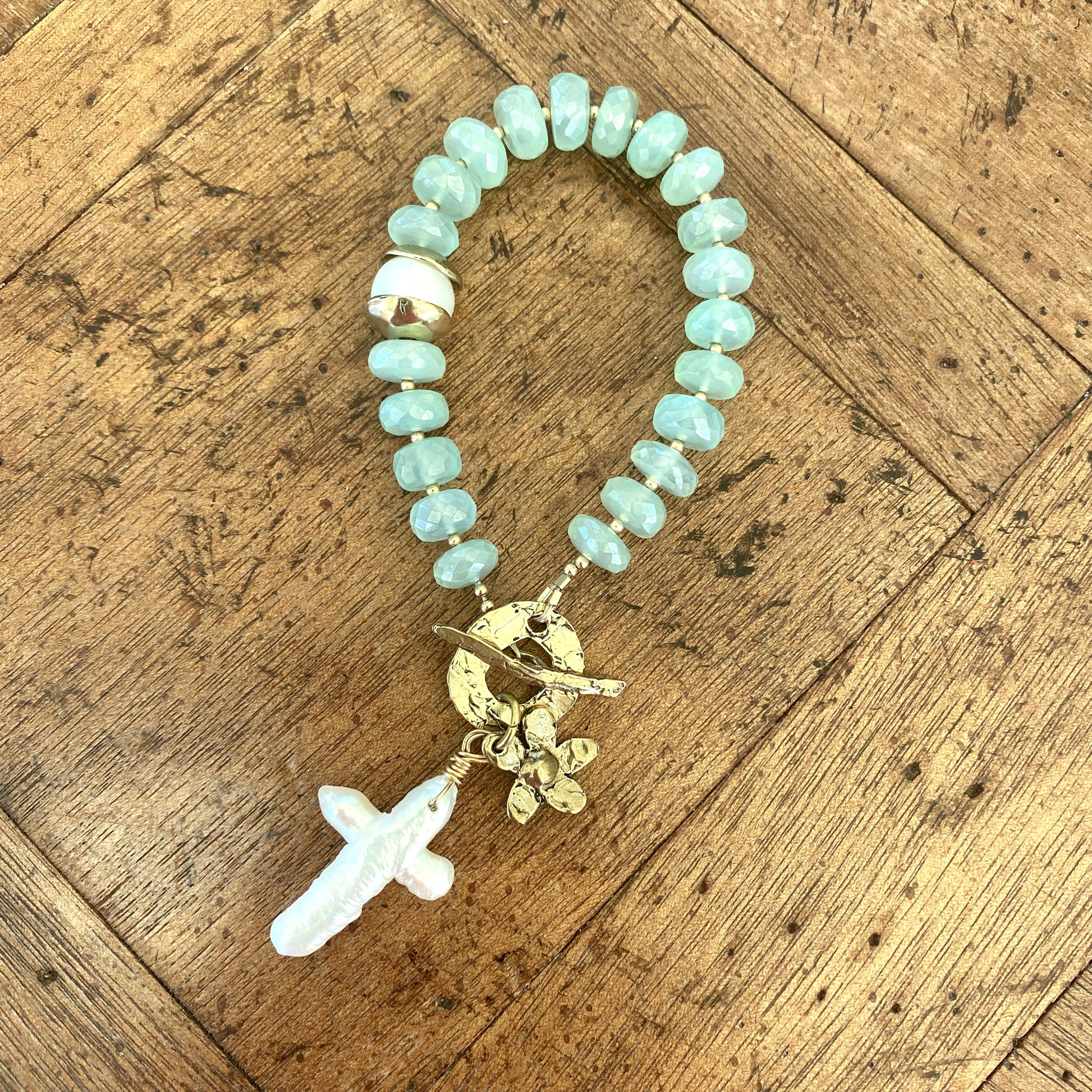 Chalcedony bracelet with cross pearl pendant and daisy charm, featuring aqua green chalcedony rondelle beads.