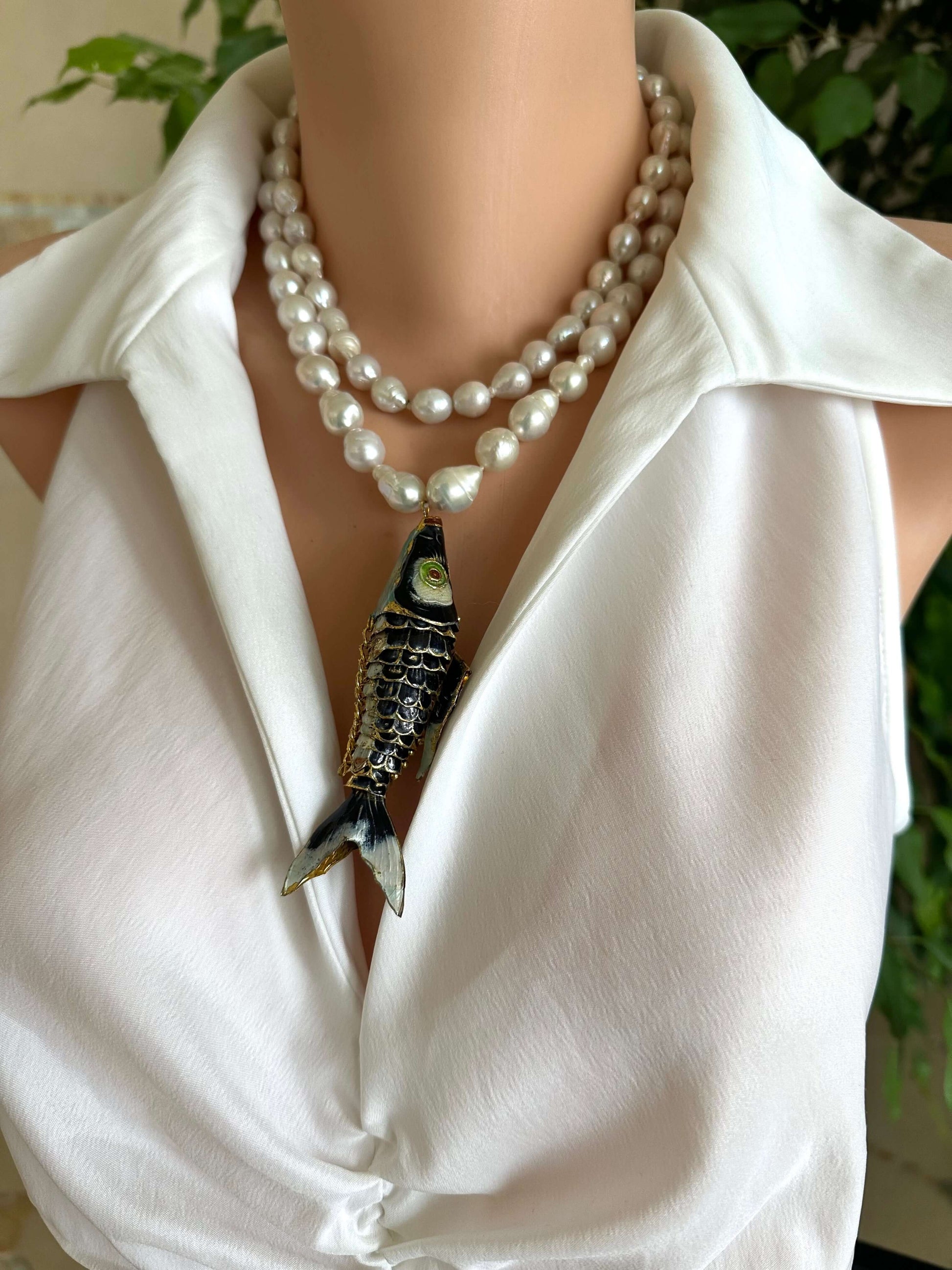 Fish pendant pearl necklace featuring a large cloisonné fish pendant and hand knotted baroque pearls.