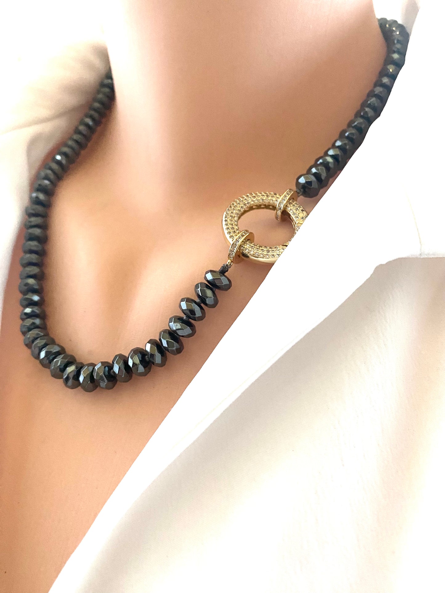 Festive Hematite Necklace showcased on a model, featuring shiny hematite beads with a gold clasp against a white shirt.
