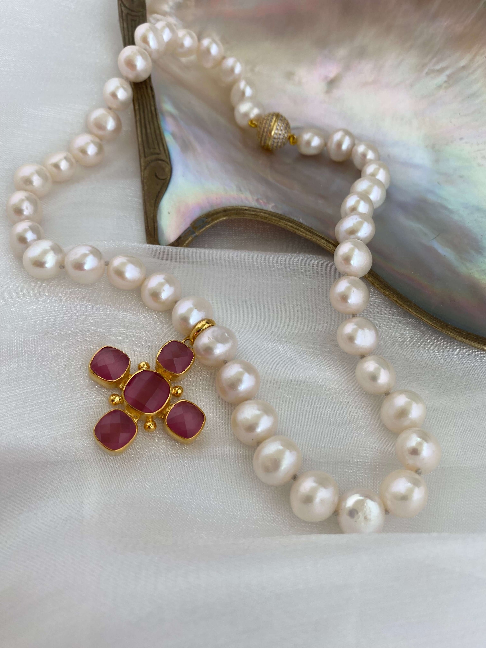 White potato pearl necklace with cross pendant showcasing luminous pearls and elegant design.