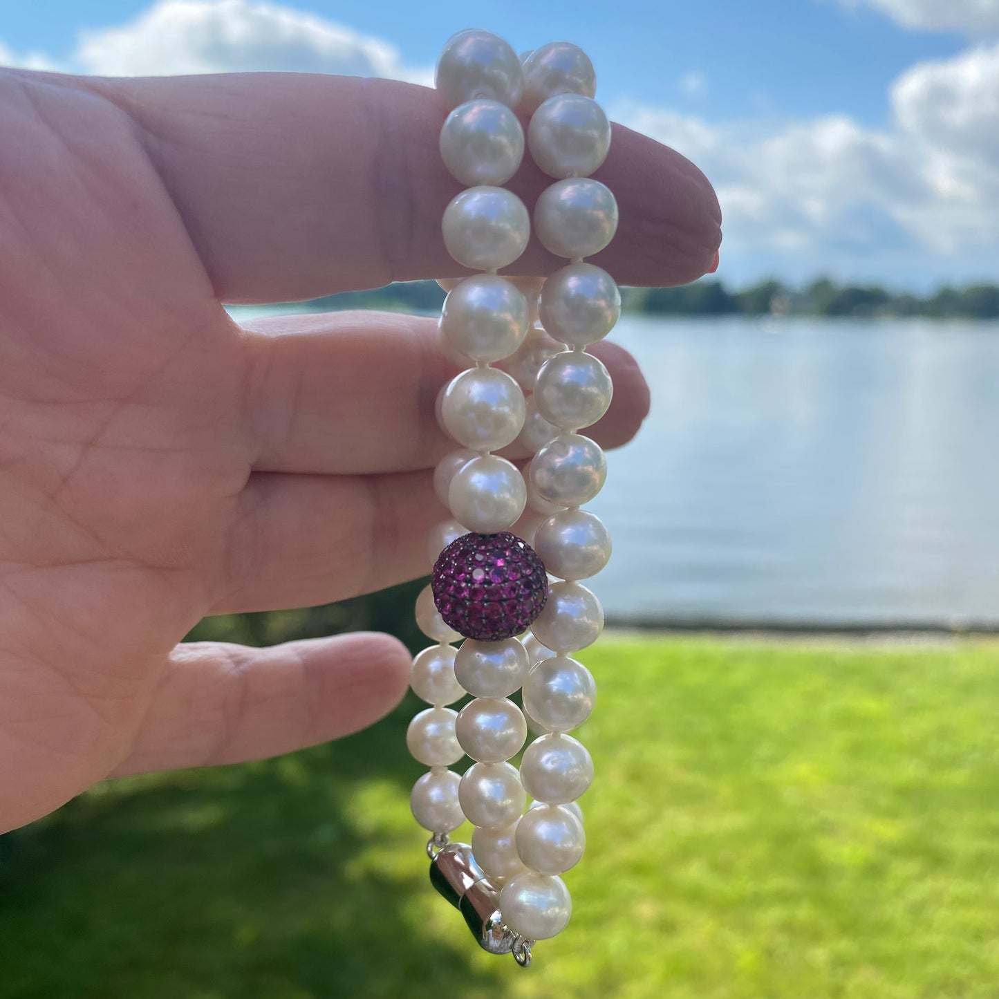 Pearl necklace with ruby red CZ bead, handmade in Canada, showcasing freshwater pearls and elegant design.