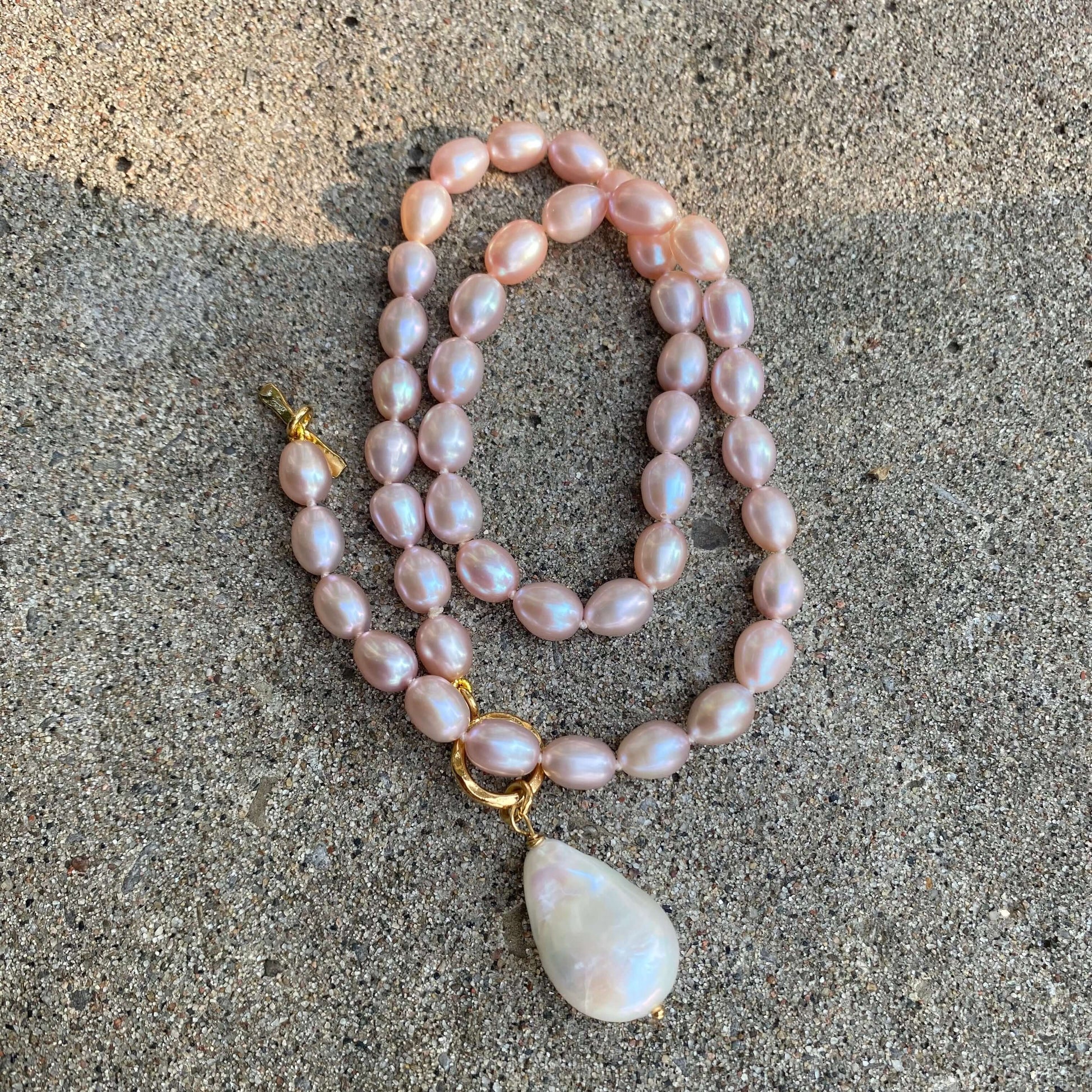 Pink pearl toggle necklace with baroque pearl displayed flat showing pearl strand and pendant detail