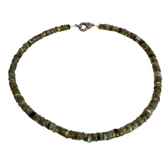 A beaded necklace made of small, irregular dark gray and olive-green stone beads with a silver-toned clasp, displayed on a plain off-white background.