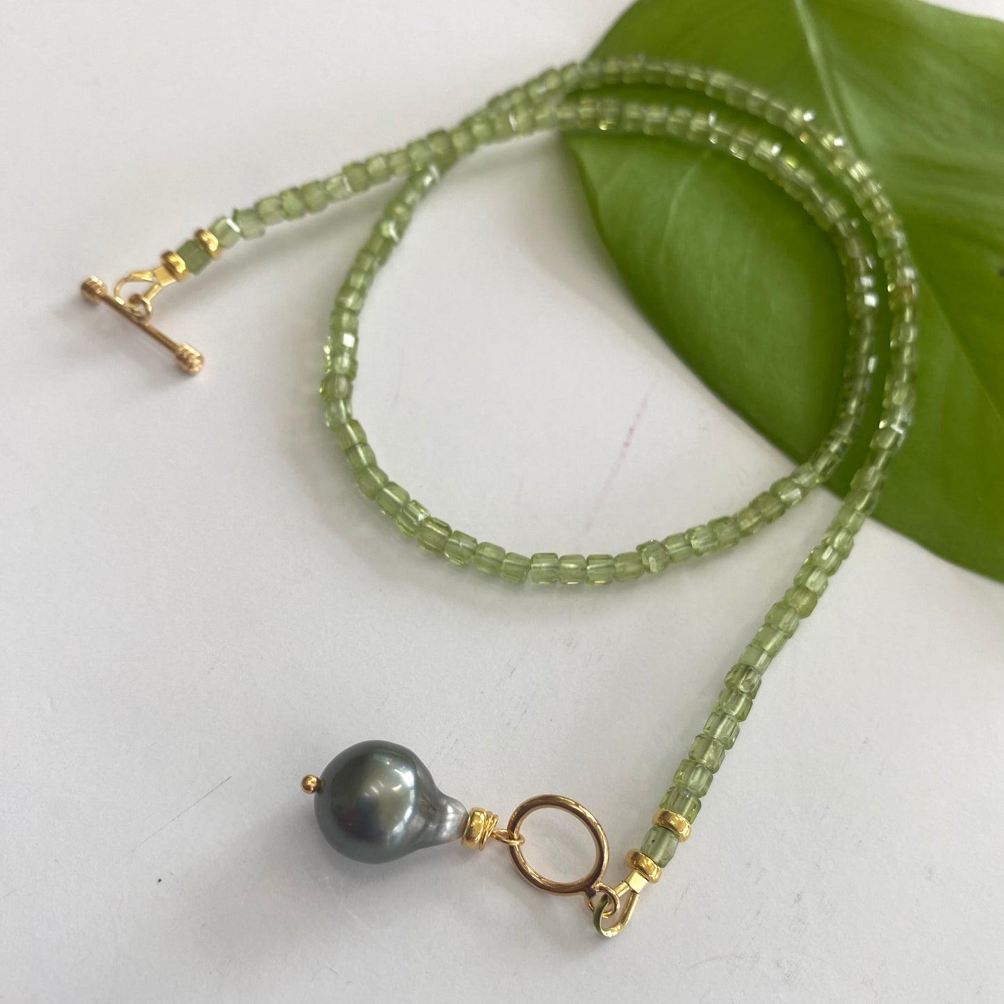 Peridot baroque pearl necklace featuring vibrant green Peridot beads and a striking Tahitian Baroque pearl pendant.