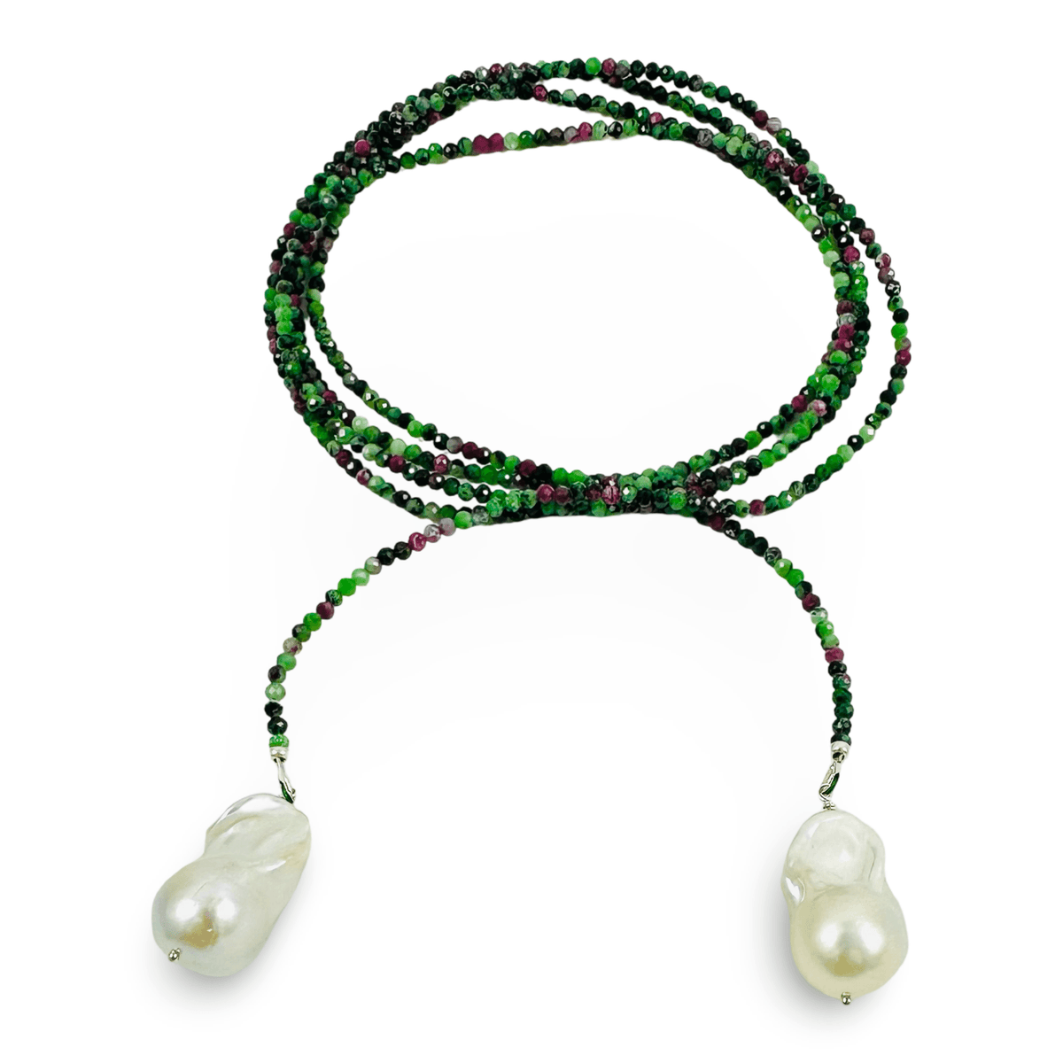 A long strand beaded necklace featuring vibrant green and deep purple beads, with two large, irregular white baroque pearls hanging from the ends, set against a plain white background.