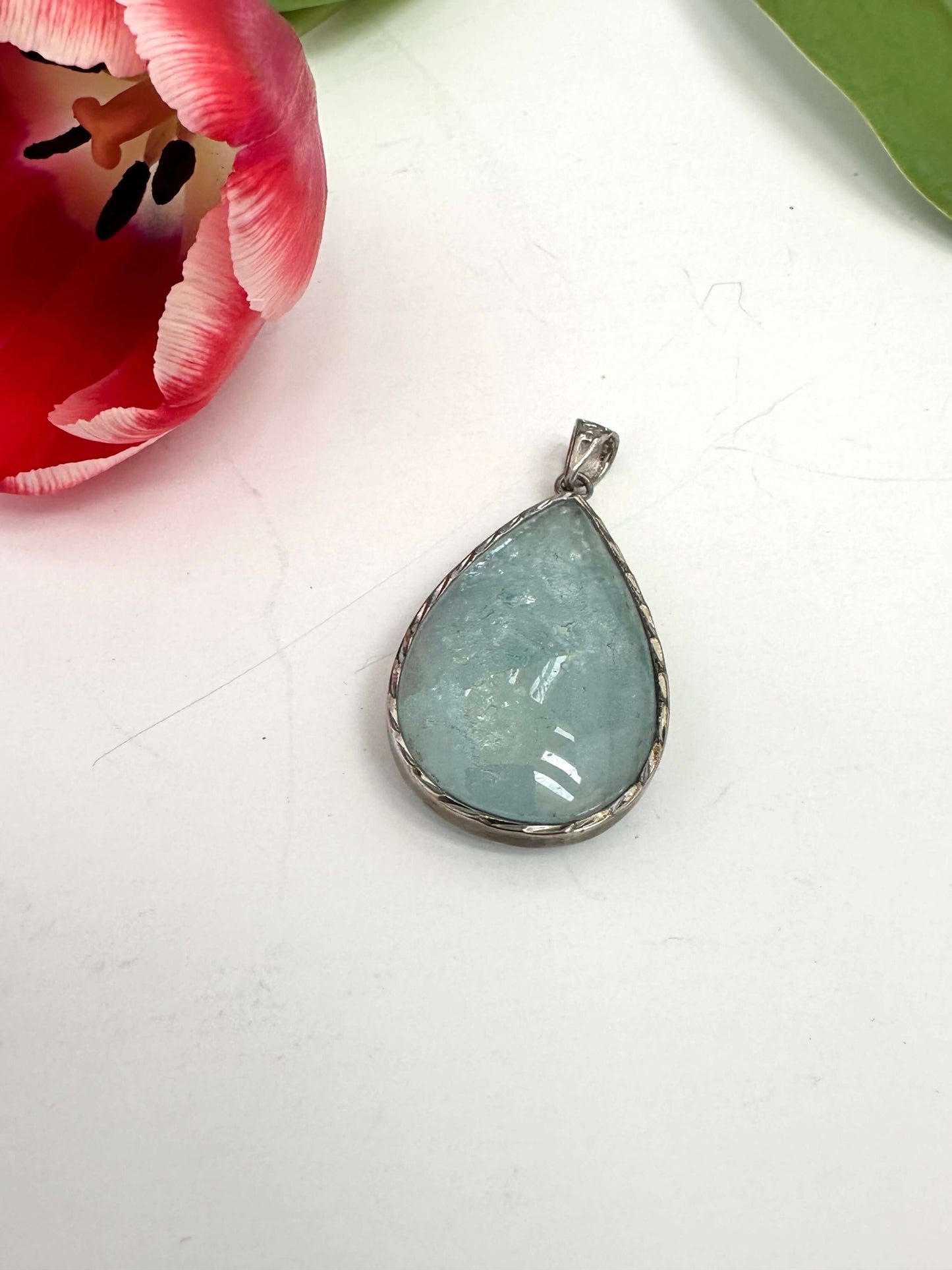 Aquamarine teardrop pendant in oxidized sterling silver featuring a pear-shaped aquamarine stone with natural inclusions.