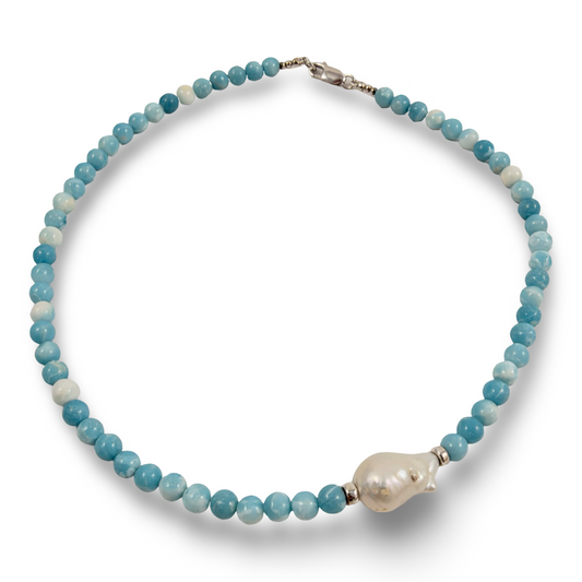 A beaded necklace featuring light blue and white round beads, accented by a large, irregular white pearl pendant and silver-toned metal clasp, shown on a plain white background.