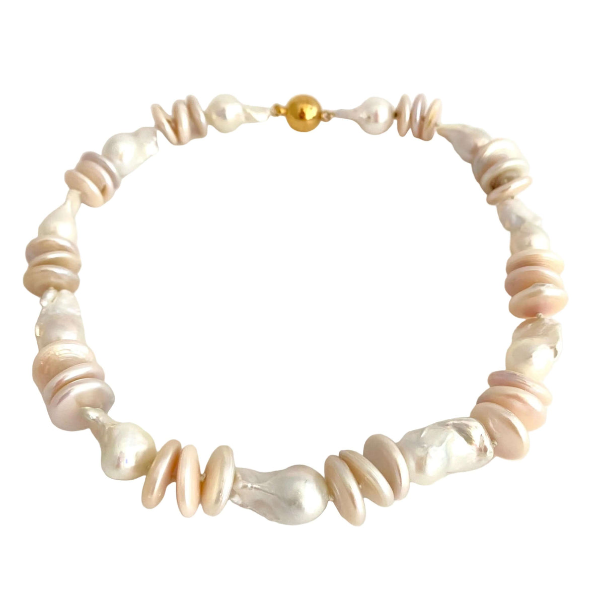 A beaded necklace made of irregular baroque pearls in white and pale pink, accented with small beige discs and a single gold bead clasp, shown on a plain off-white background.