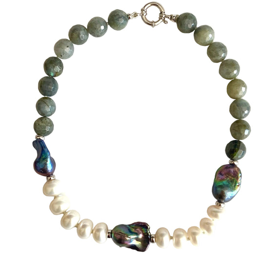 A beaded necklace featuring olive green faceted beads, white baroque pearls, and two large iridescent abalone shell accents, displayed on a clean white background.