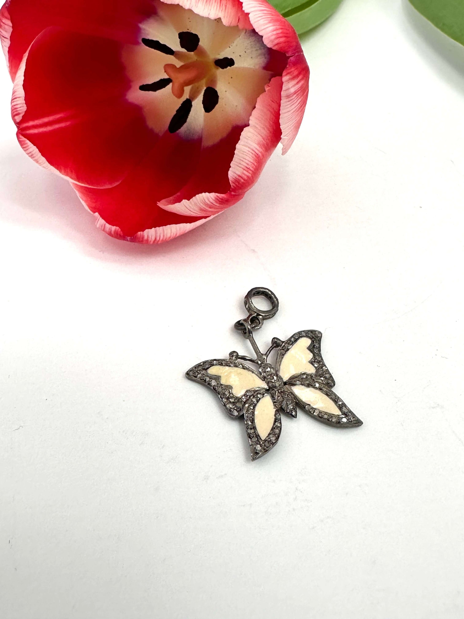 Enamel butterfly pendant with diamond pavé in sterling silver, featuring soft off-white enamel wings and diamond accents.