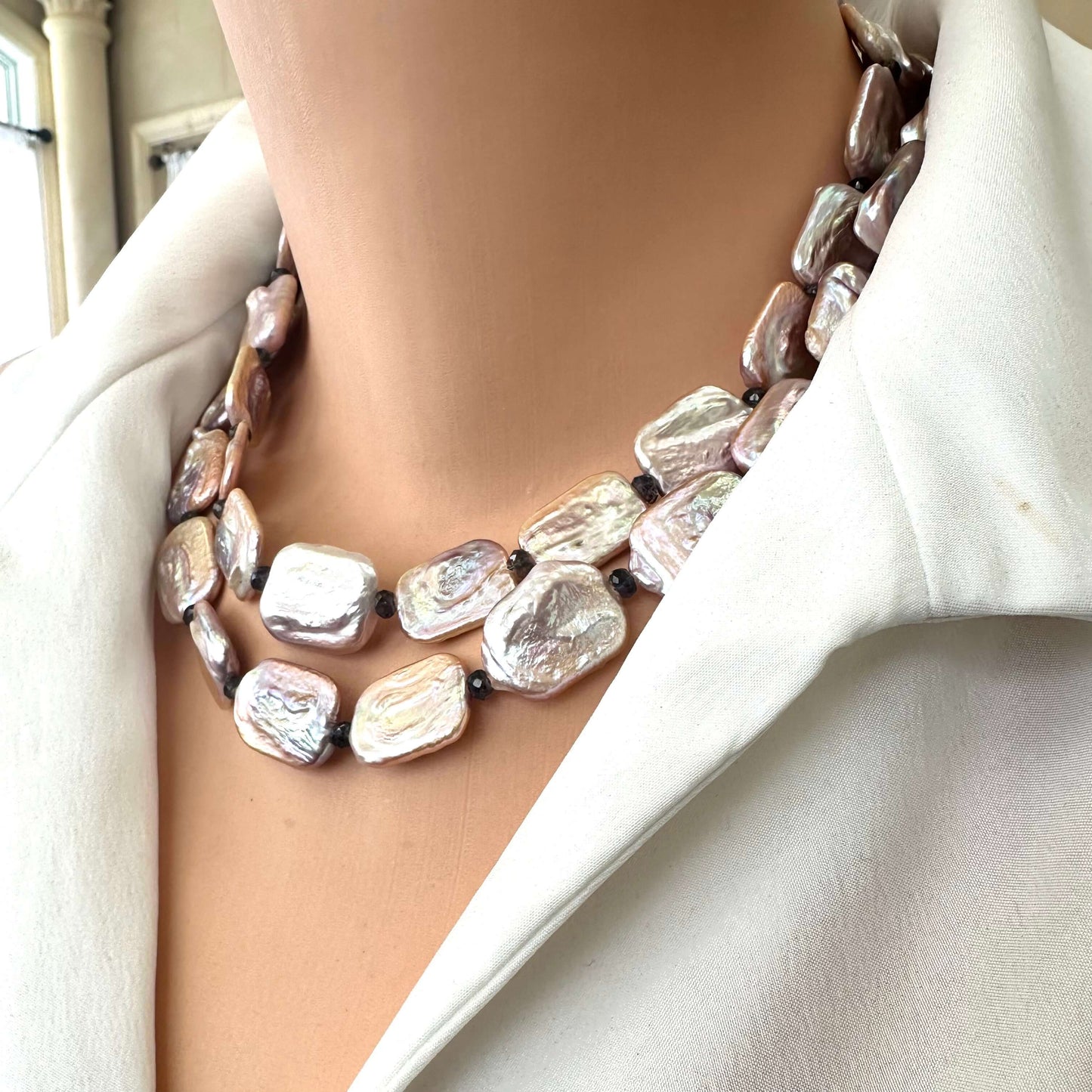 Side view of Statement Pearl Necklace with purple pink rectangular pearls and navy iolite gemstones on mannequin.