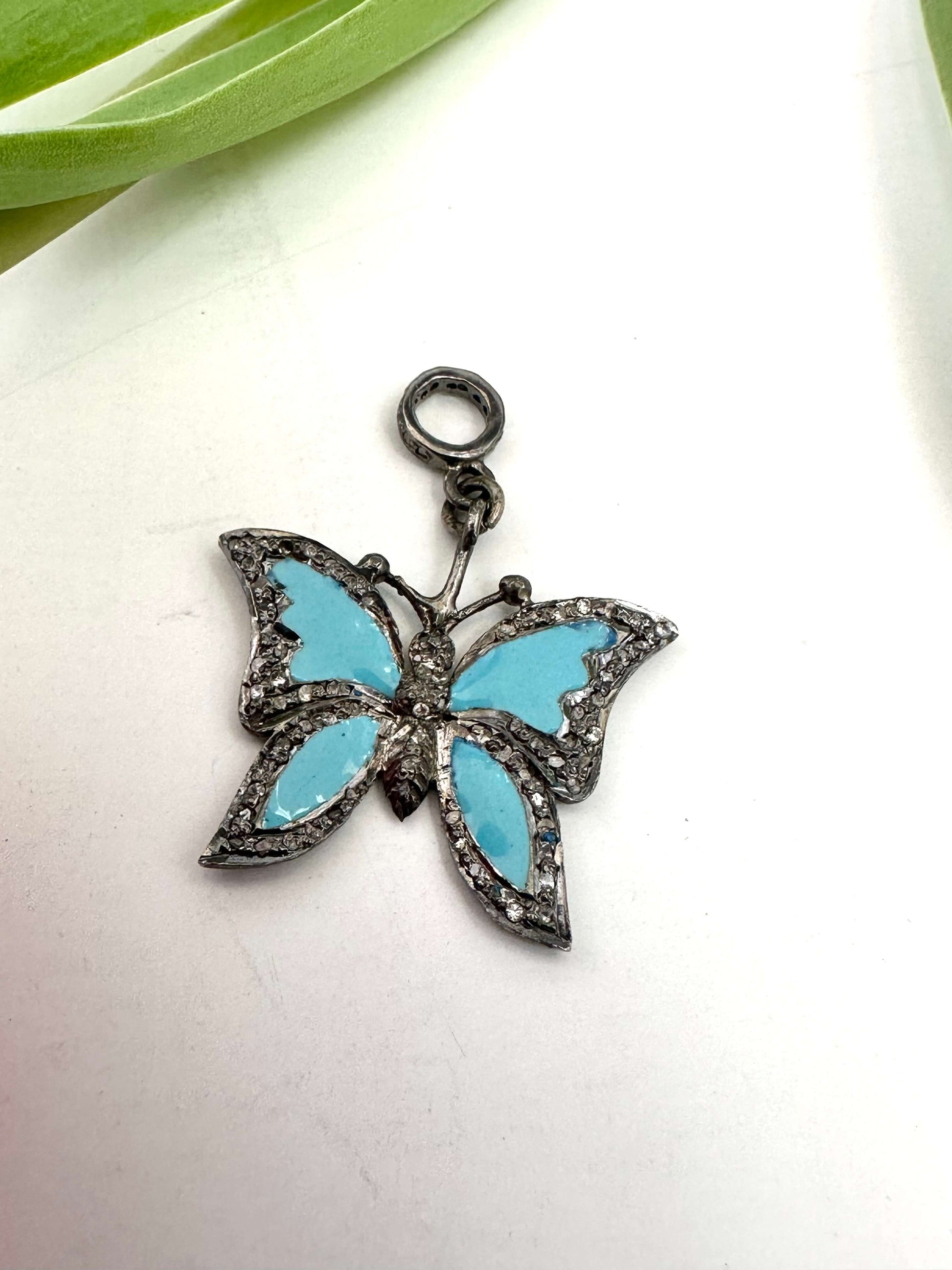 Blue enamel butterfly pendant with diamond pavé in sterling silver, displaying vibrant blue wings and sparkling detail.