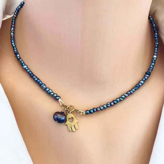 Black pearl hamsa necklace worn on neckline with 14k gold filled charm, handmade in Canada