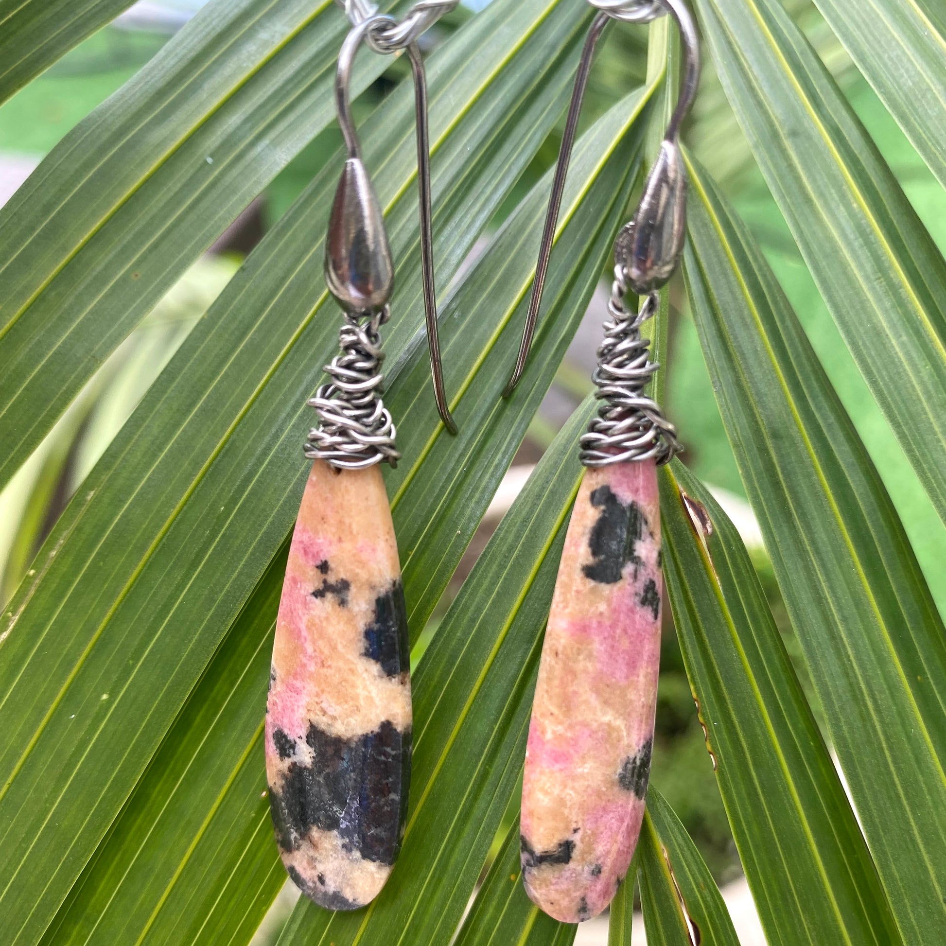 Rhodonite teardrop earrings with natural pink gemstone veining and black rhodium hooks, handmade in Canada