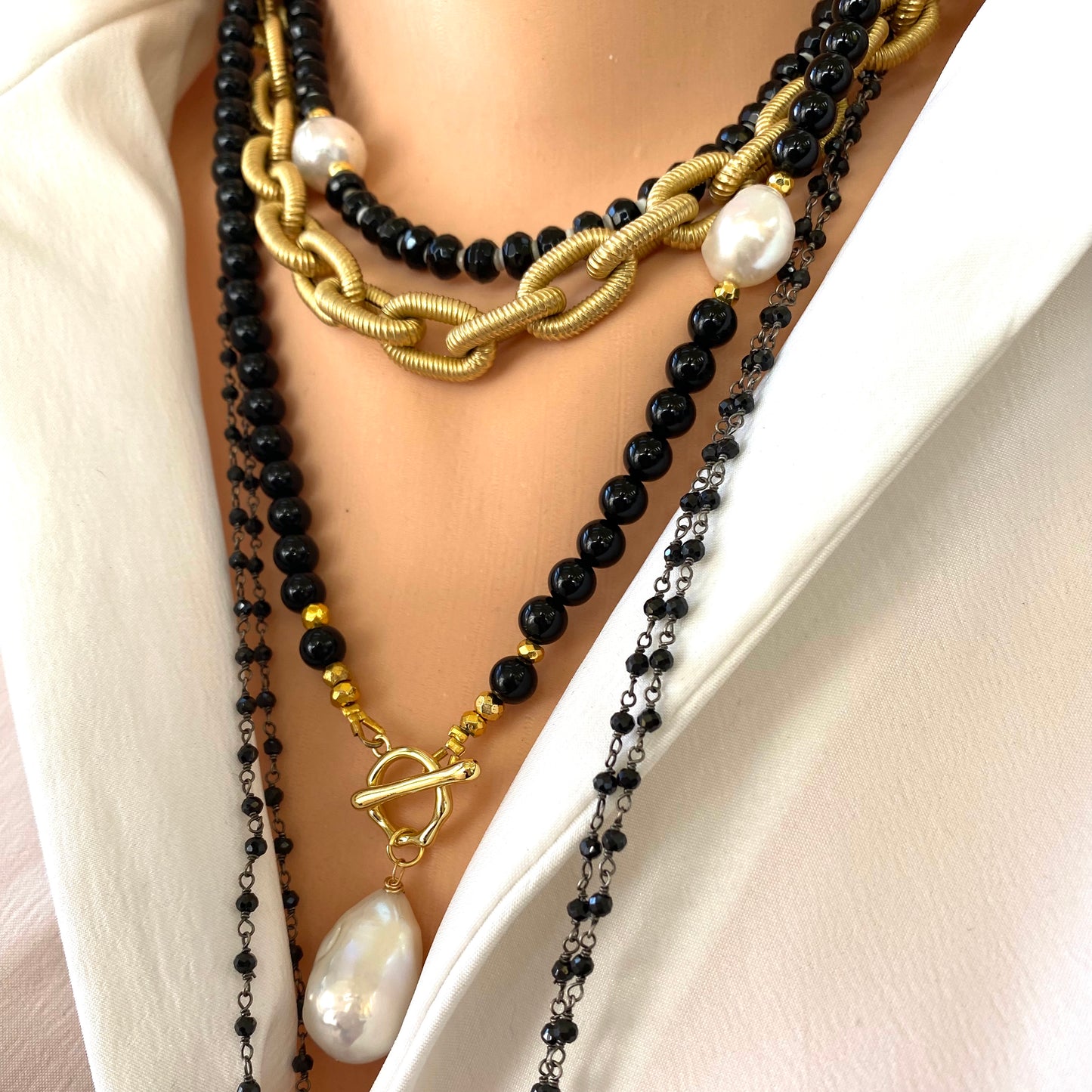 Black onyx pearl choker necklace worn layered with black beads gold accents and baroque pearl
