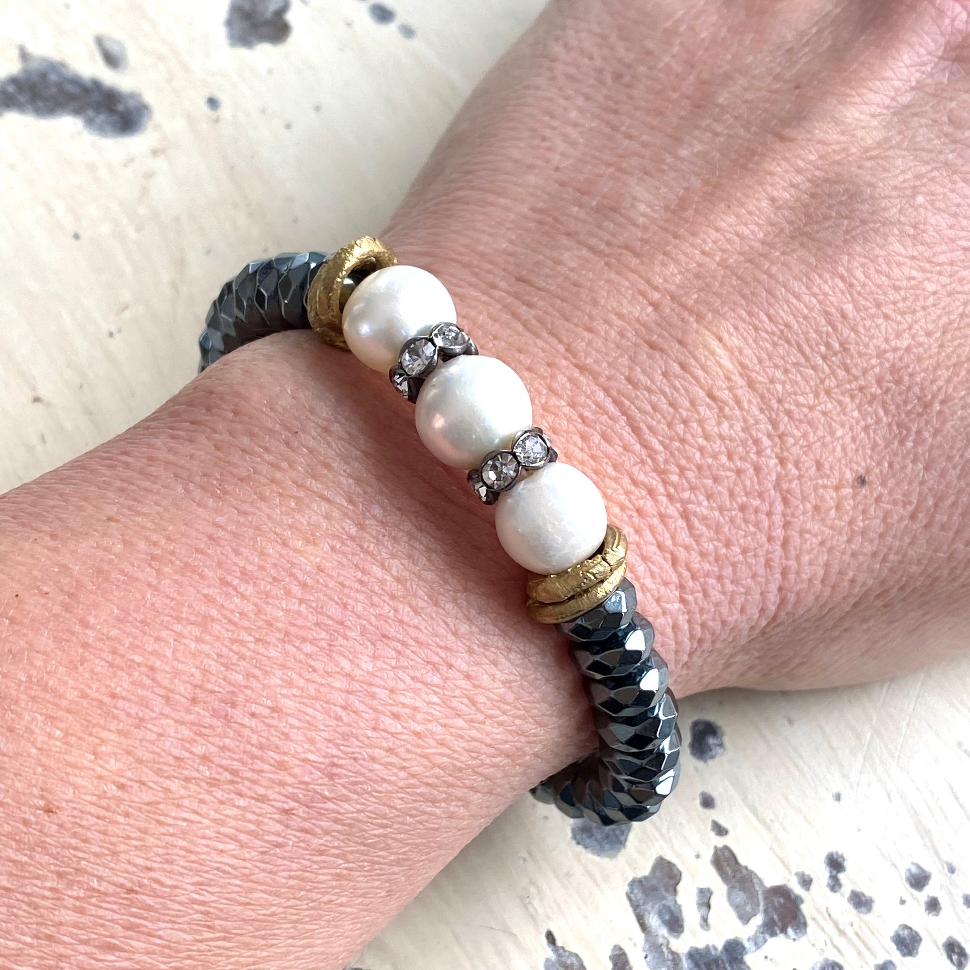 Freshwater pearl hematite stretch bracelet worn on wrist highlighting contrast of pearls and hematite