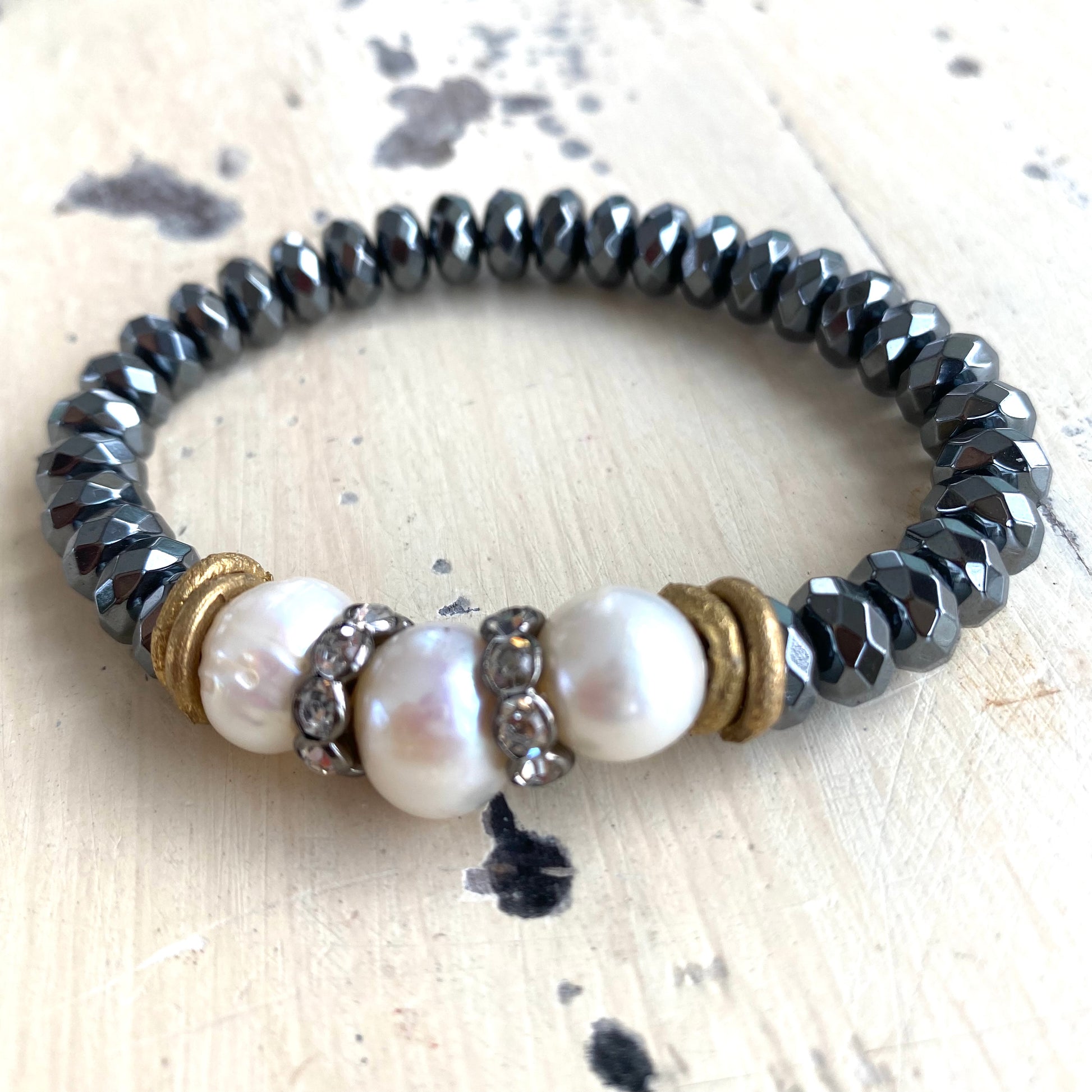 Freshwater pearl hematite stretch bracelet displayed flat with baroque pearl and brass accents