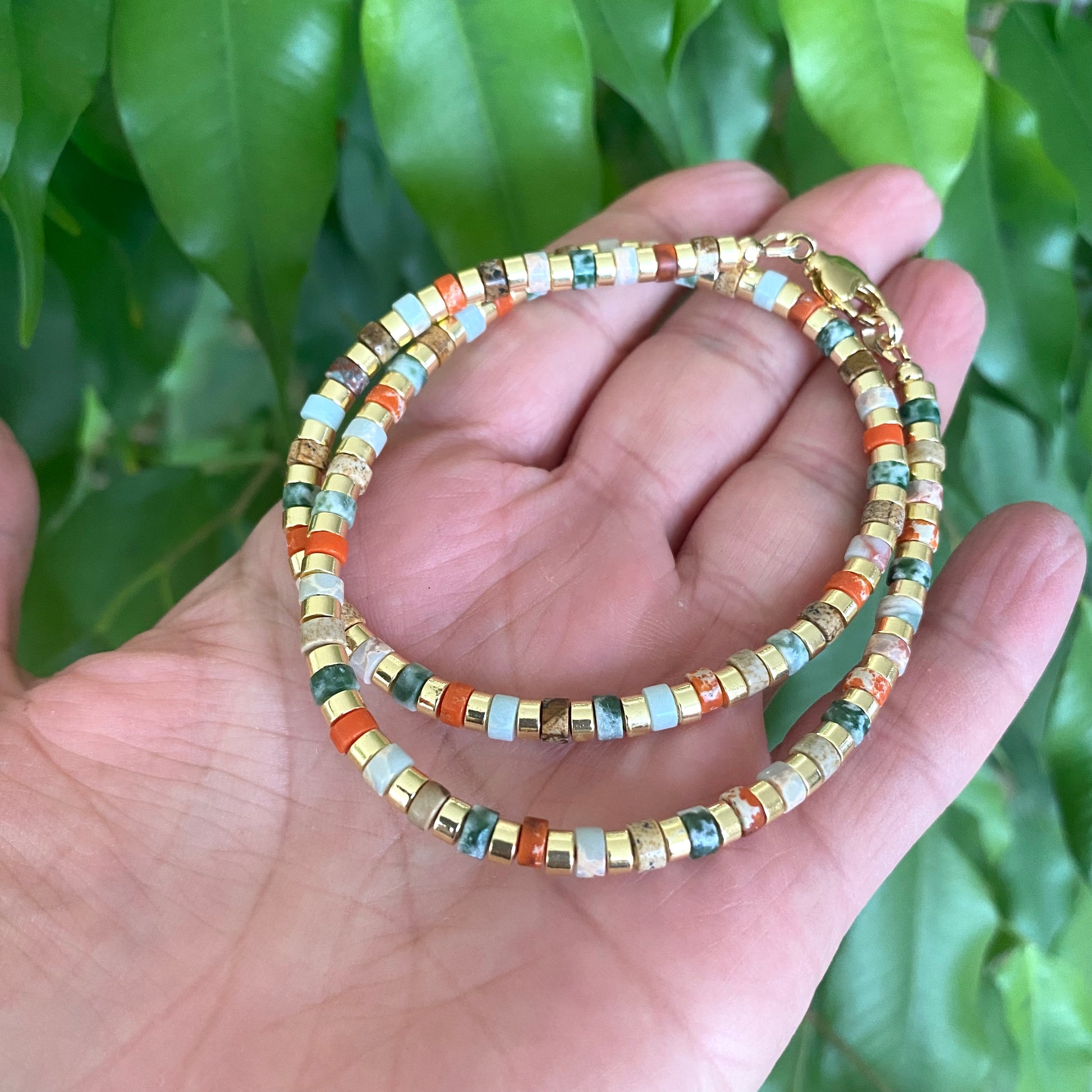 Gemstone choker necklace with multi color beads and hematite held in hand, vibrant and stylish accessory for everyday wear.