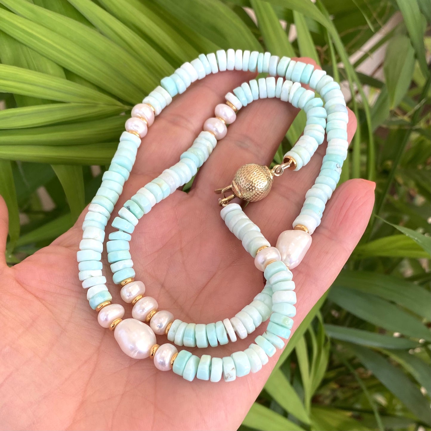 Sky blue opal pearl necklace held in hand with freshwater pearls and gold vermeil details, handmade in Canada