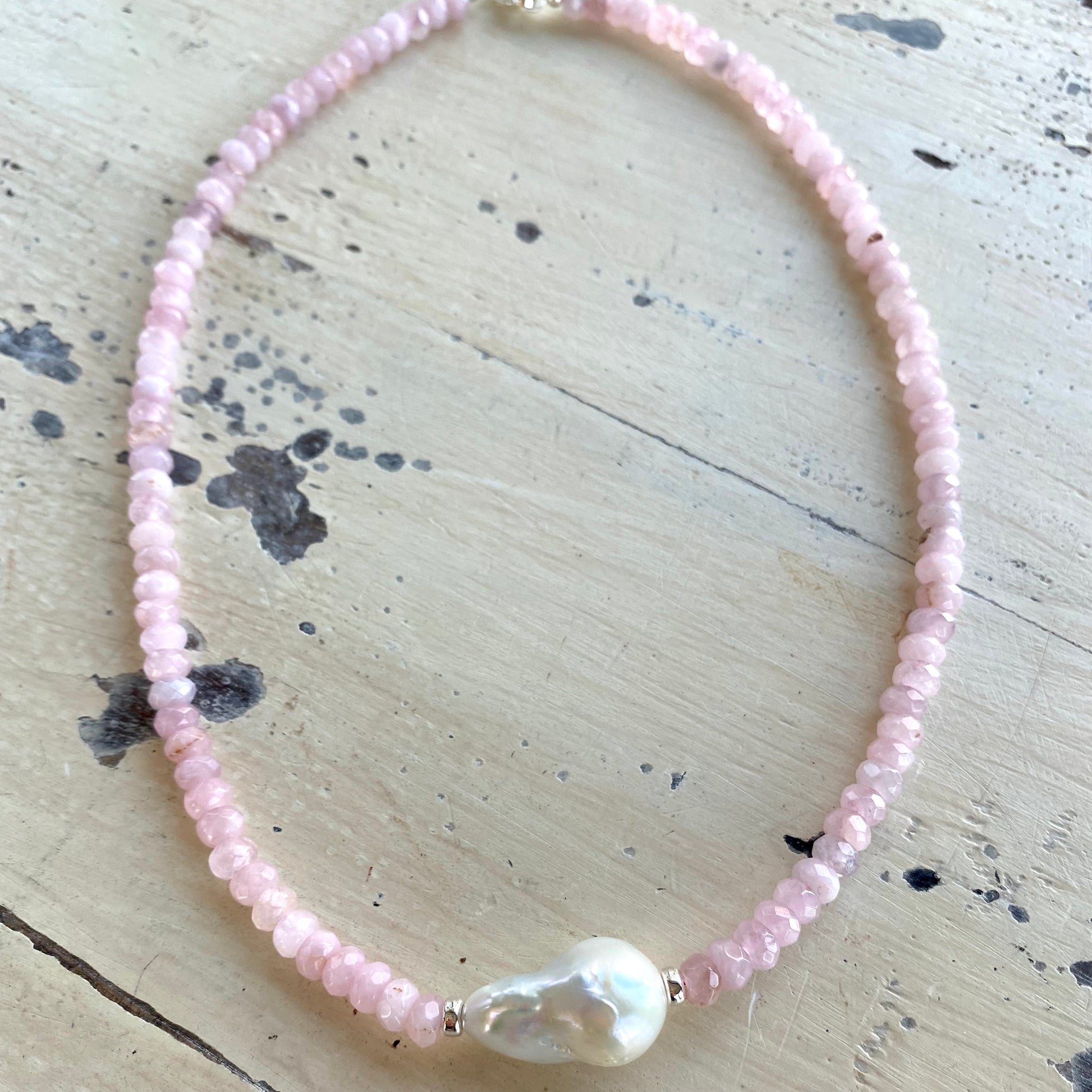 Rose quartz pearl necklace laid out to show full length and baroque pearl focal point, handmade in Canada